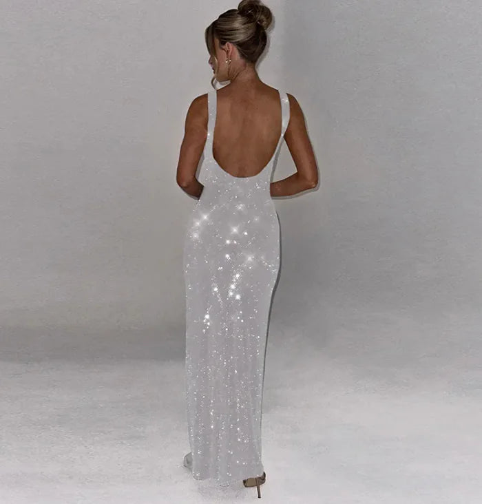 Woman wearing a sparkly silver evening gown against a plain background