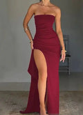 Red strapless dress with a high slit on a plain background